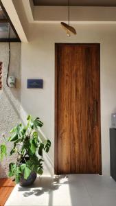 a wooden door in a room with a plant at Thousand Sunday Ubud in Ubud