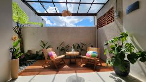 a patio with two chairs and a table and some plants at Thousand Sunday Ubud in Ubud