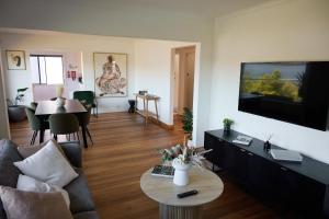a living room with a couch and a tv at Waterfront home with outdoor spa bath and mountain views - 5 min drive to city in Montagu Bay