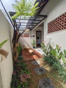 a courtyard of a house with a palm tree at Thousand Sunday Ubud in Ubud