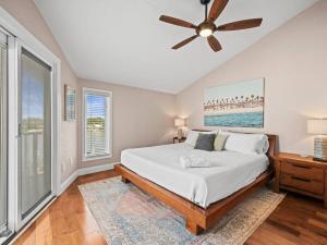 a bedroom with a bed and a ceiling fan at Beautiful Roomy Condo with Sunrise & Sunset Views in St Pete Beach