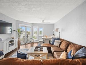 a living room with a couch and a table at Beautiful Roomy Condo with Sunrise & Sunset Views in St Pete Beach