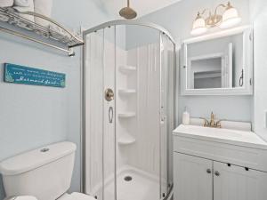 a bathroom with a shower and a toilet and a sink at Beautiful Roomy Condo with Sunrise & Sunset Views in St Pete Beach +44 photos