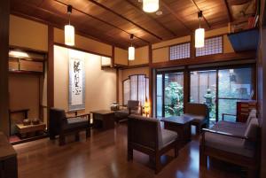 a living room with chairs and tables and windows at Ryokan Tanabe 旅館田邊 in Takayama
