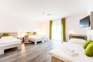 a living room with two beds and a tv at Hotel Anna Hilden in Hilden +30 photos