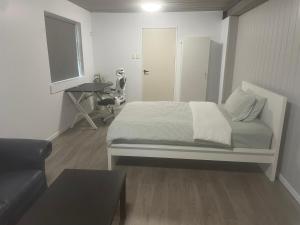 una camera da letto bianca con un letto e una scrivania di Spacious studio unit a Rochedale South