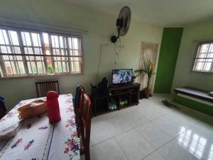 a living room with a table and a television at Linda Casa Com Vista Pro Mar in Ilha Comprida