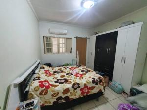 a bedroom with a bed with a floral bedspread at Linda Casa Com Vista Pro Mar in Ilha Comprida +22 photos