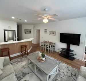 a living room with a flat screen tv and a table at Amazing Newly Renovated Condo at Sea Trail Resort in Sunset Beach