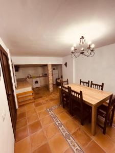 une cuisine et une salle à manger avec une table et des chaises en bois dans l'établissement Casa Rural Camino de la Fuente, à Teroleja