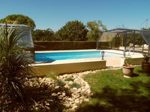a swimming pool in a yard with a garden sidx sidx sidx at Gîte Belfloret in Renneville +8 photos