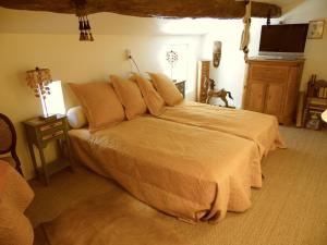 a bedroom with a large bed with orange sheets at Gîte Belfloret in Renneville