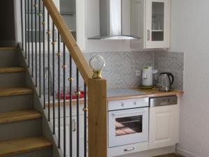a kitchen with white cabinets and a staircase at Gîte Belfloret in Renneville