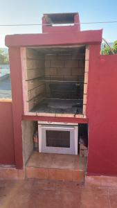 une cuisine avec un micro-ondes dans un mur rouge dans l'établissement La casa amarilla de Luis y Eileen, à La Vila Joiosa