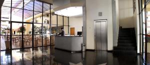 a lobby with a man standing at a counter in a building at Dexter Hotel - Volta Redonda in Volta Redonda