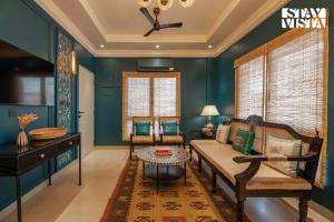 een woonkamer met groene muren en een bank bij StayVista at Nayak House with Luxury Rooms, Terrace, Wi-Fi at Kolkata in Calcutta