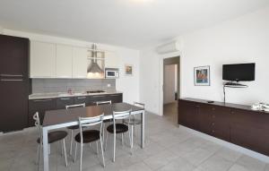 eine Küche mit Tisch und Stühlen und einem Fernseher in der Unterkunft Amazing Apartment In Cavallino-Treporti in Cavallino-Treporti