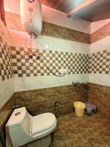 a bathroom with a toilet and a balloon on the wall at Pine Paradise Homestay in Shimla +10 photos