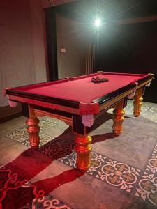 a red pool table sitting on top of a floor at Hostel FUJI in Phnom Penh