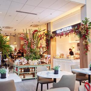 a restaurant with tables and chairs and people in a store at 38 Park Avenue right in the heart of IT Park Cebu, 55 inches TV, wifi in Tabok