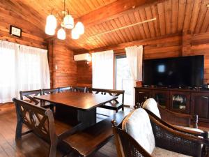 a dining room with a table and a flat screen tv at ヴィータ牛窓 in Setouchi