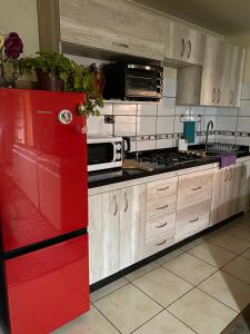 a kitchen with a red refrigerator in a kitchen at Departamento Centro Curicó in Curicó