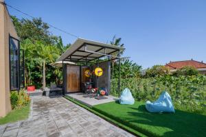un jardin avec une maison et une pelouse recouverte de gazon artificiel dans l'établissement Wander Havens, à Canggu