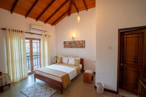 a bedroom with a bed and a wooden door at Windy Ridge Kandy in Kandy