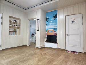 an empty room with a white door and a poster of a car at Daemyeongyeok - house of gallery in Daegu