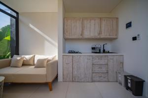 un salon avec un canapé et une cuisine dans l'établissement Wander Havens, à Canggu