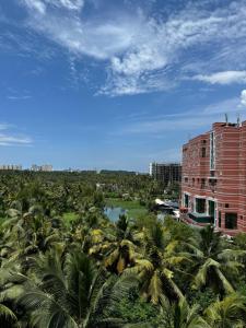 a building with a bunch of palm trees next to a building at Aami dhivahi guest house 01 in Trivandrum