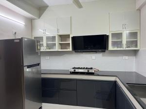 a kitchen with white cabinets and a stainless steel refrigerator at Aami dhivahi guest house 01 in Trivandrum