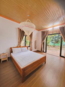 a bedroom with a large bed and a chandelier at Thuy Tien Ecolodge in Cat Tien +120 photos