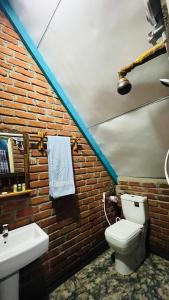 a bathroom with a white toilet and a sink at Ali Adi Eco Tree House in Sigiriya