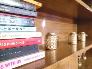 a stack of books sitting on top of a shelf at Pine Paradise Homestay in Shimla