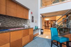 a kitchen with wooden cabinets and a blue chair at Bethesda 1BR w Concierge Gym WD nr Metro WDC-333 in Bethesda