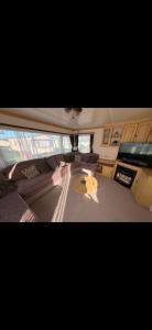 a living room with a couch and a yellow umbrella at 46 Newport Caravan Park Award Shortlisted Family Caravan in Hemsby