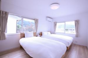 浅川にある81 Guest House -ANKI-の窓が2つある部屋にベッドが2つある