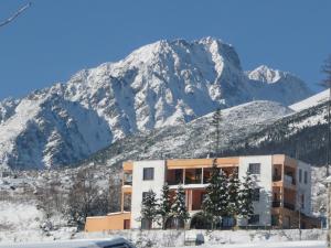 a building in front of a snow covered mountain at Penzion Partizan in Vysoke Tatry - Horny Smokovec