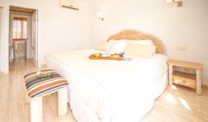 a white bed with a white blanket on it at Ona Village Cala d'Or in Cala d´Or