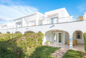 a white house with a balcony and a yard at Ona Village Cala d'Or in Cala d´Or