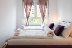 - un lit blanc avec des serviettes devant une fenêtre dans l'établissement Bright 1BDR with Balcony & Parking, à Zagreb