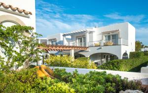 a white house with plants in front of it at Ona Village Cala d'Or in Cala d´Or