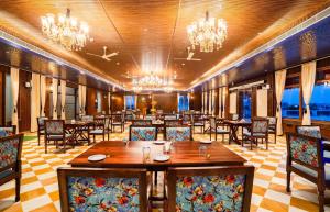 a dining room with tables and chairs and chandeliers at The Kurki Heritage in Jaipur