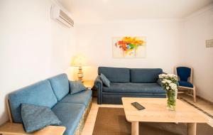 a living room with a blue couch and a table at Ona Village Cala d'Or in Cala d´Or