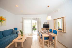 uma sala de estar com uma mesa e um sofá azul em Ona Village Cala d'Or em Cala d´Or