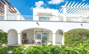 a white house with a patio with a table and chairs at Ona Village Cala d'Or in Cala d´Or