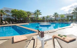 a pool at a hotel with chairs and a table at Ona Village Cala d'Or in Cala d´Or