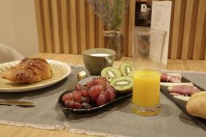 a table with a tray of fruit and a glass of orange juice at Hotel Puerto de Luarca in Luarca