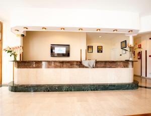 a lobby with a bar with a tv on the wall at Ona Village Cala d'Or in Cala d´Or +37 photos